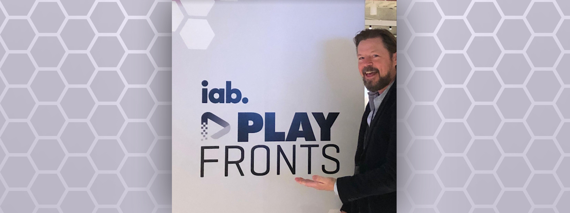 Ben Johnson standing in front of PlayFronts IAB sign